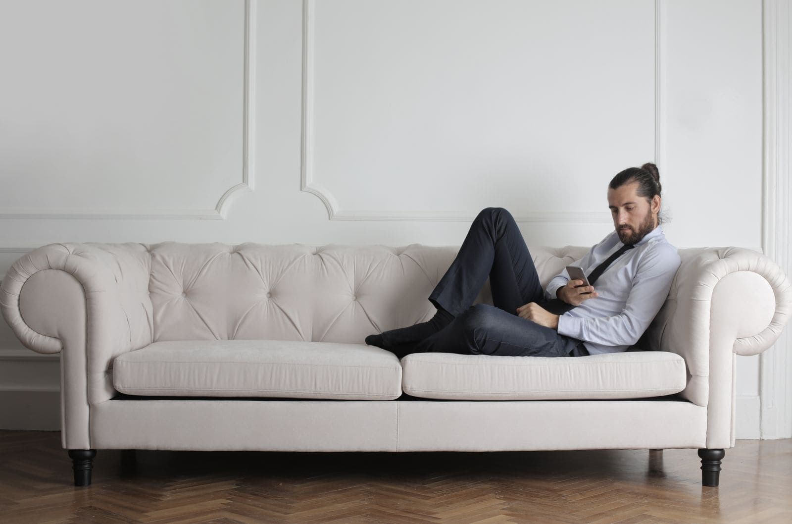 A man checking his phone while relaxing on the sofa