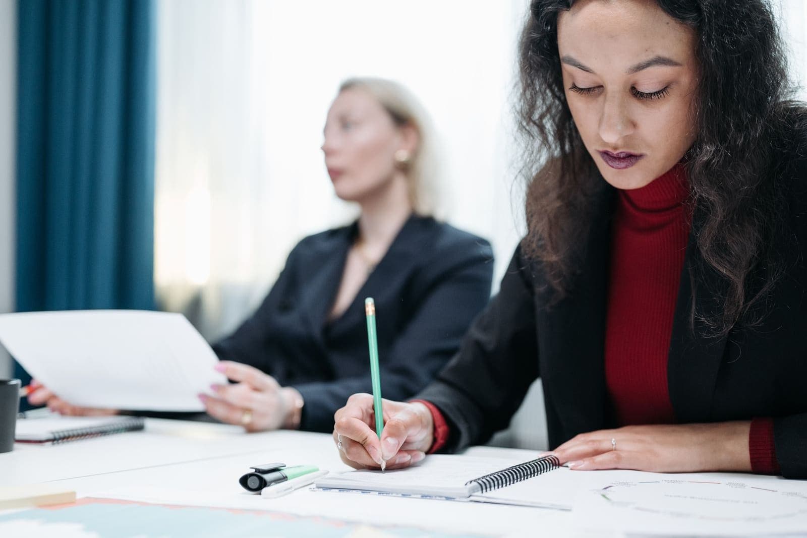 A woman taking notes at her desk